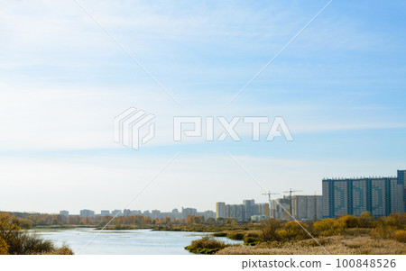Panorama with river and nature and residential high-rise buildings in the distance 100848526