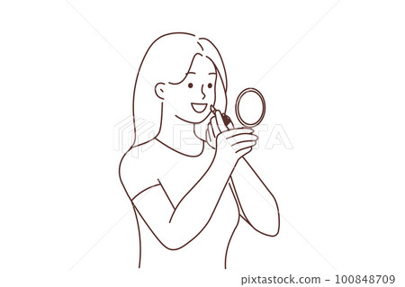 Smiling woman apply lipstick  100848709