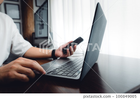 hands working on a laptop computer 100849005