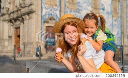 Mother and little daughter tourists with ice cream, close-up 100849159