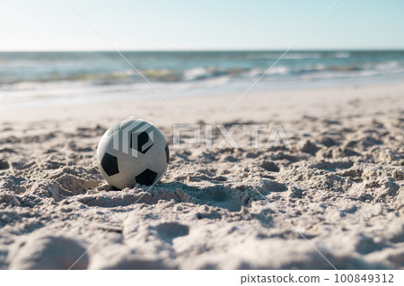 Soccer ball on sandy beach with scenic view of beautiful sea and clear sky in the background Soccer ball on sandy beach with scenic view of beautiful sea and clear sky in the background 100849312