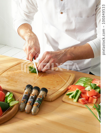Restaurant chef and a set of jars with different spices in a wooden box in the kitchen. Kazan, 17 March 2023 Restaurant chef and a set of jars with different spices in a wooden box in the kitchen. Kazan, 17 March 2023 100849533
