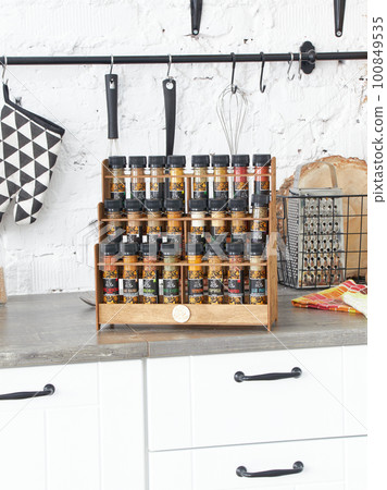 A set of glass jars with different spices in a wooden box in the kitchen. Kazan, 17 March 2023 A set of glass jars with different spices in a wooden box in the kitchen. Kazan, 17 March 2023 100849535