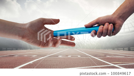 Image of athlete's hands passing relay baton over racing track in sports stadium 100849617