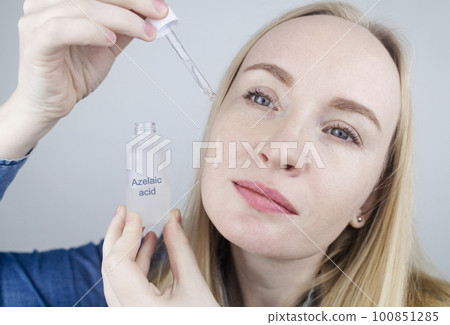 Azelaic acid. The girl applies azelainates to her face. Laboratory research. Facial skin care. Dermatological serum. Emulsion for the treatment of rosacea, acne and skin problems Azelaic acid. The girl applies azelainates to her face. Laboratory research. Facial skin care. Dermatological serum. Emulsion for the treatment of rosacea, acne and skin problems 100851285
