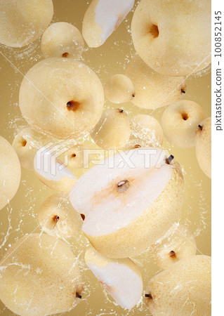 Creative layout made from Fresh Chinese pear and water Splashing on a yellow background Creative layout made from Fresh Chinese pear and water Splashing on a yellow background 100852145