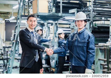 工廠員工與商業夥伴握手 100852959