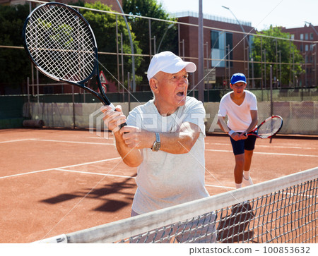 tennis players of different generations playing tennis court tennis players of different generations playing tennis court 100853632