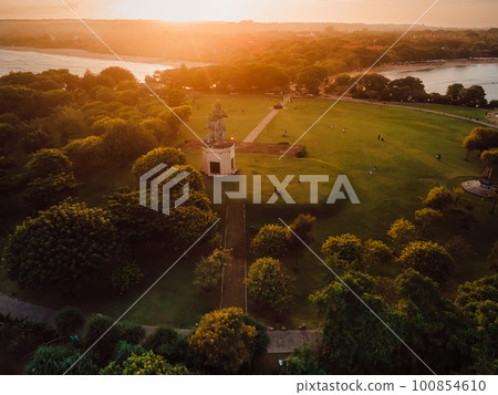 Park in Nusa Dua with monument and warm sunset in Bali, Aerial view 100854610