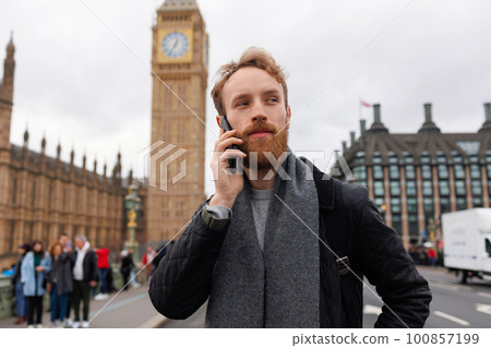Man talks on a mobile phone while standing near Big Ben in London Man talks on a mobile phone while standing near Big Ben in London 100857199