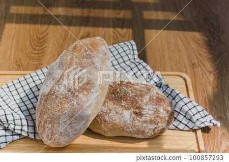 Loaf of freshly homemade artisan bread on wooden board. 100857293