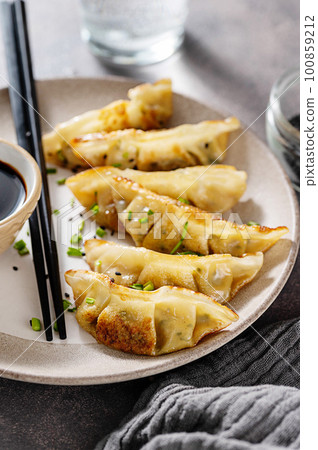 Fried closeup dumplings gyoza with soy sauce, and chopsticks. Fried closeup dumplings gyoza with soy sauce, and chopsticks. 100859212
