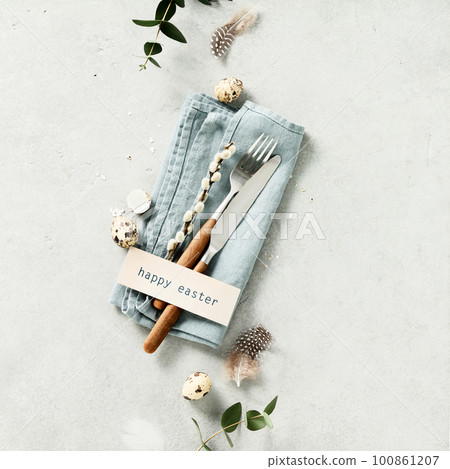 Easter table setting with fork, knife, linen napkin, eggs and feathers flat lay Easter table setting with fork, knife, linen napkin, eggs and feathers flat lay 100861207
