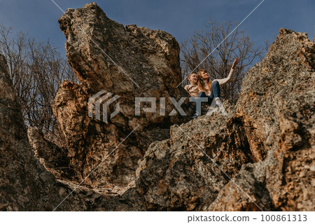Mother and Son Sitting Together on Forest Rock Mother and Son Sitting Together on Forest Rock 100861313