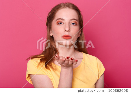 Close up portrait of attractive charming lovely girl with perfect hairdo and excellent make up, sending air kiss, says goodbye on distance, flirts with boyfriend, isolated on bright pink background. 100862698