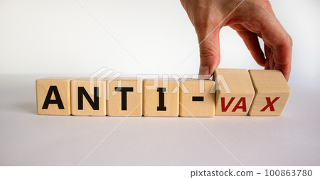 Anti-vax symbol. Doctor turns cubes with words 'anti-vax'. Beautiful white background. Copy space. Business, medical covid-19 vaccination or anti-vax concept. Anti-vax symbol. Doctor turns cubes with words 'anti-vax'. Beautiful white background. Copy space. Business, medical covid-19 vaccination or anti-vax concept. 100863780