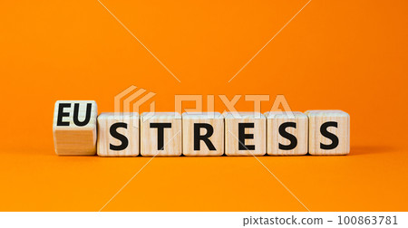 Eustress or stress symbol. Turned the wooden cube and changed the concept word Eustress to Stress. Beautiful orange table orange background, copy space. Psychlogical and stress or eustress concept. Eustress or stress symbol. Turned the wooden cube and changed the concept word Eustress to Stress. Beautiful orange table orange background, copy space. Psychlogical and stress or eustress concept. 100863781