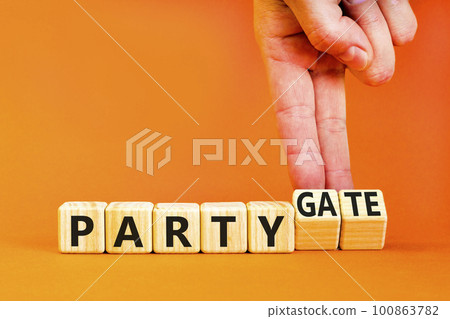 Party and partygate symbol. Concept words Party and Partygate on wooden cubes. Businessman hand. Beautiful orange table orange background. Business party and partygate concept. Copy space. Party and partygate symbol. Concept words Party and Partygate on wooden cubes. Businessman hand. Beautiful orange table orange background. Business party and partygate concept. Copy space. 100863782