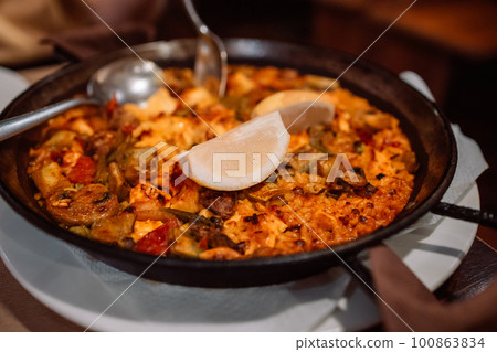 Traditional spanish seafood paella, Classic dish of Spain, seafood paella in traditional pan on rustic blue concrete background . 100863834