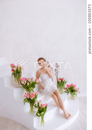 Smiling woman feels joy and happiness, holds a pink tulip. 100863873