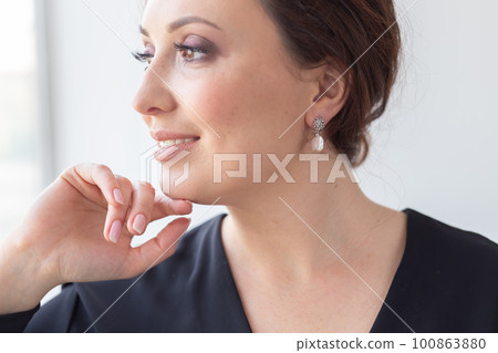 Fashionable and stylish woman in trendy jewelry pearl earrings . Fashion look beauty and style. Natural makeup and easy styling Fashionable and stylish woman in trendy jewelry pearl earrings . Fashion look beauty and style. Natural makeup and easy styling 100863880