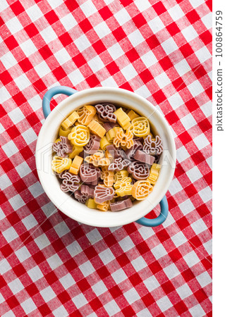 Pasta of various scary shapes. Uncooked halloween pasta in pot. 100864759