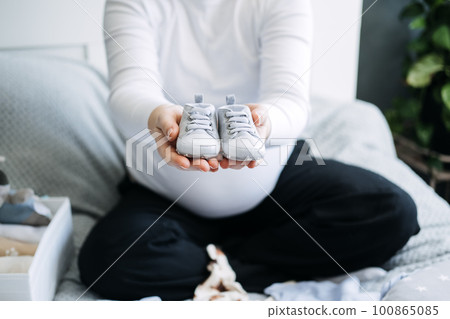 How to Organize Newborn Baby Clothes. Pregnant woman Using ornament boxes, baskets, or dividers to organize baby clothes in dresser drawers How to Organize Newborn Baby Clothes. Pregnant woman Using ornament boxes, baskets, or dividers to organize baby clothes in dresser drawers 100865085