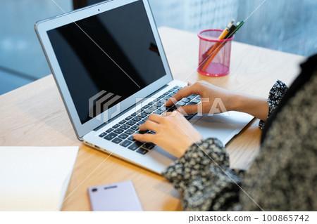 Woman's hand operating a personal computer 100865742