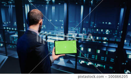 Support specialist using tablet with greenscreen display in modern data center, checking blank chroma key template. Database admin working with isolated mockup and hardware industry. Tripod shot. Support specialist using tablet with greenscreen display in modern data center, checking blank chroma key template. Database admin working with isolated mockup and hardware industry. Tripod shot. 100866205