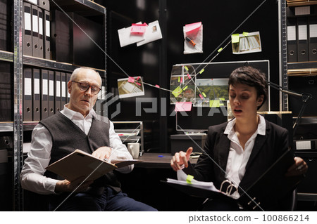 Private investigators discussing criminal investigations case with remote coworkers during online videocall meeting conference. Police officers working overhours at crime scene report in arhive room Private investigators discussing criminal investigations case with remote coworkers during online videocall meeting conference. Police officers working overhours at crime scene report in arhive room 100866214