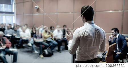 Speaker at Business Conference with Public Presentations. Audience at the conference hall. Entrepreneurship club. Rear view. Horisontal composition. Background blur. Speaker at Business Conference with Public Presentations. Audience at the conference hall. Entrepreneurship club. Rear view. Horisontal composition. Background blur. 100866531