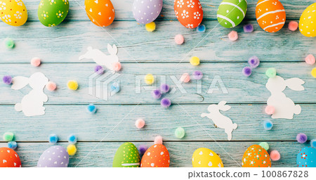 Easter Day Concept. Top view holiday banner background web design white colorful easter eggs and paper bunny rabbit on blue wood background with copy space, celebration greeting, overhead, template 100867828