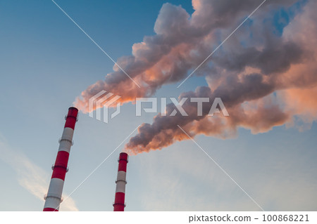 Environmental pollution - factory smokestacks emitting white smoke against sky 100868221