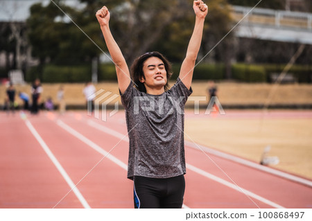 男賽跑者在賽道上做膽量姿勢 男賽跑者在賽道上做膽量姿勢 100868497