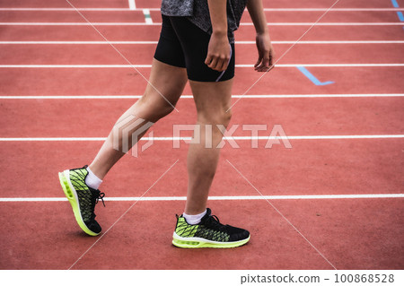 Male runner taking start on athletics track 100868528