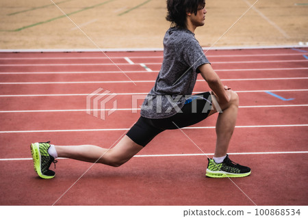 跑步者在田徑跑道上伸展 100868534