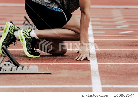 Runners at the starting line on the track of an athletics stadium 100868544