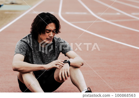 Male runner checking smart watch 100868563