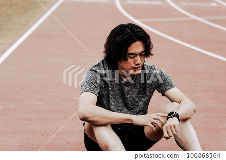 Male runner checking smart watch 100868564