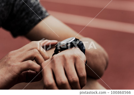 Male runner checking smart watch 100868566