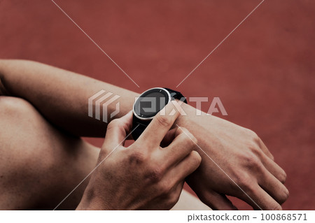 Male runner checking smart watch 100868571
