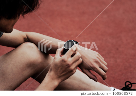 Male runner checking smart watch Male runner checking smart watch 100868572