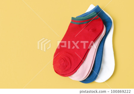 The Socks of different colors on yellow color background. The Socks of different colors on yellow color background. 100869222