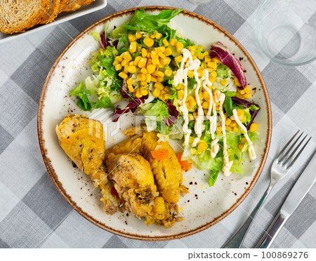 Baked chicken pieces with salad of lettuce and corn Baked chicken pieces with salad of lettuce and corn 100869276