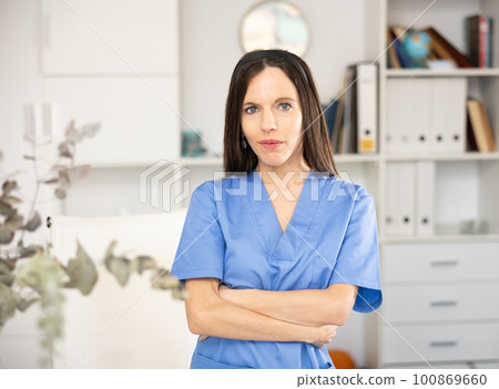Woman doctor standing inside office, looking at camera 100869660