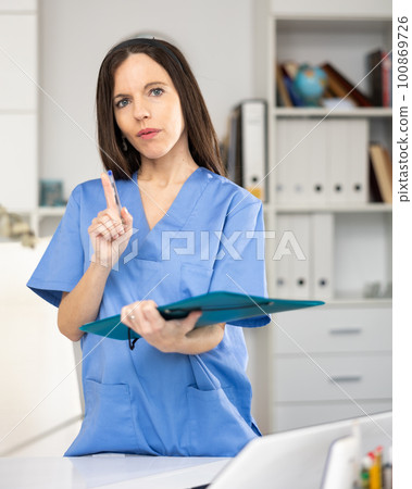 Portrait of female doctor with folder Portrait of female doctor with folder 100869726
