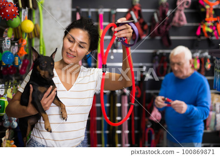 Woman with her dog in pet shop Woman with her dog in pet shop 100869871