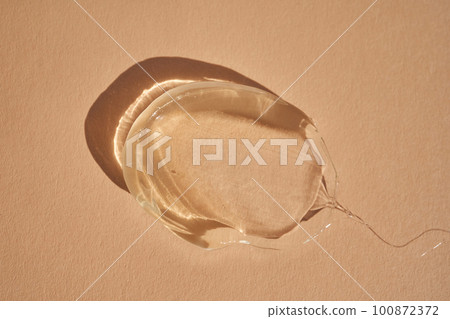 The texture of a yellow transparent gel cosmetic. The texture of a yellow transparent gel cosmetic. 100872372
