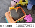 Infants playing in the sandbox 100872931