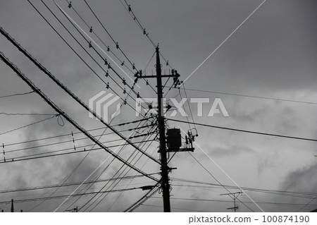多雲天氣下支撐多根電線的電線桿/電線桿 多雲天氣下支撐多根電線的電線桿/電線桿 100874190